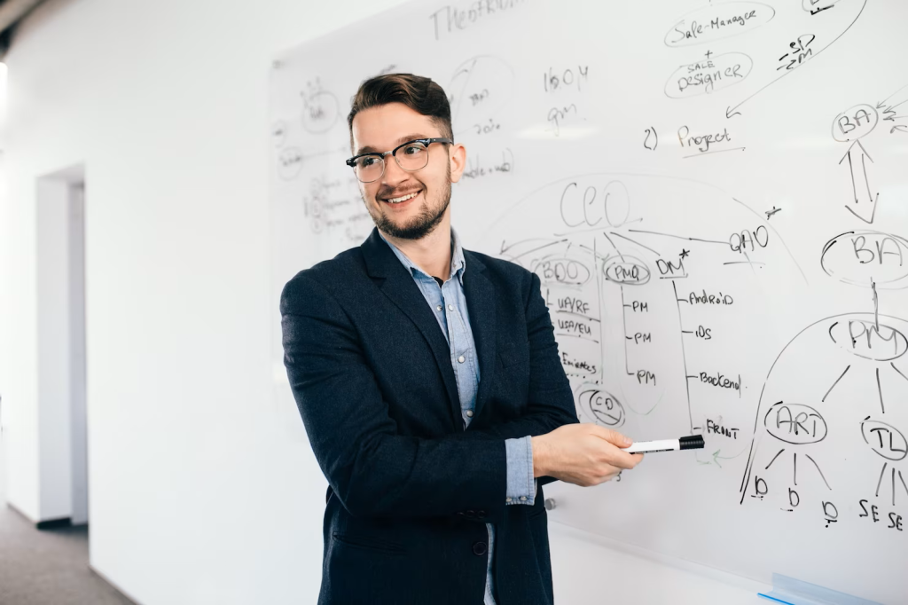young-attractive-dark-haired-man-glasses-is-showing-business-plan-whiteboard-he-wears-blue-shirt-dark-jacket-he-is-smiling-side_197531-546.png