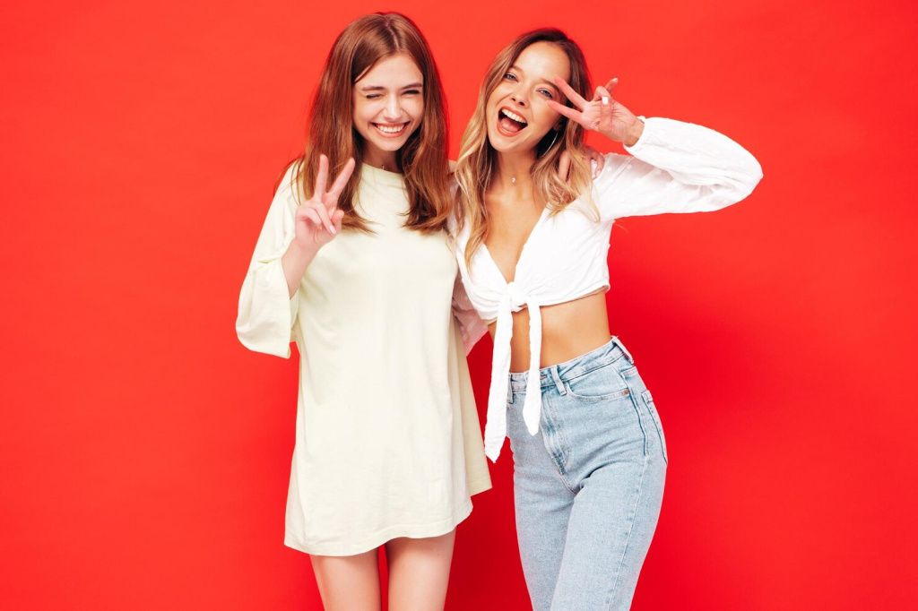 two-young-beautiful-smiling-brunette-hipster-female-trendy-summer-clothes-sexy-carefree-women-posing-near-red-wall-positive-models-having-fun-cheerful-happy-shows-peace-sign_158538-.jpg