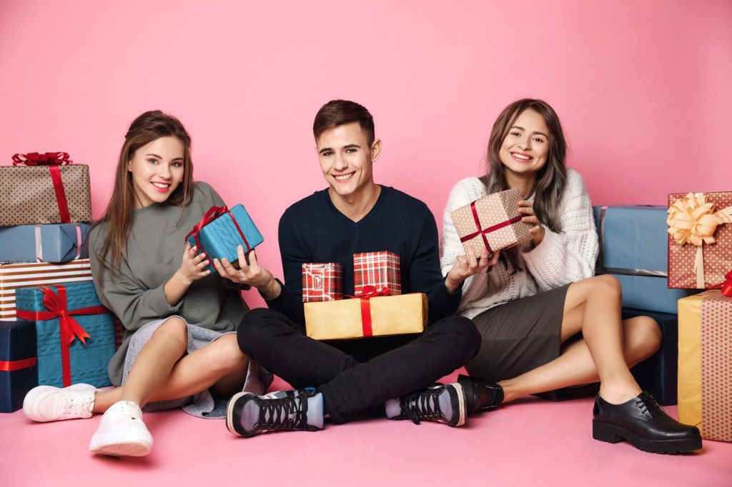 young-friends-sitting-among-christmas-gift-boxes-pink_176420-7390.jpg