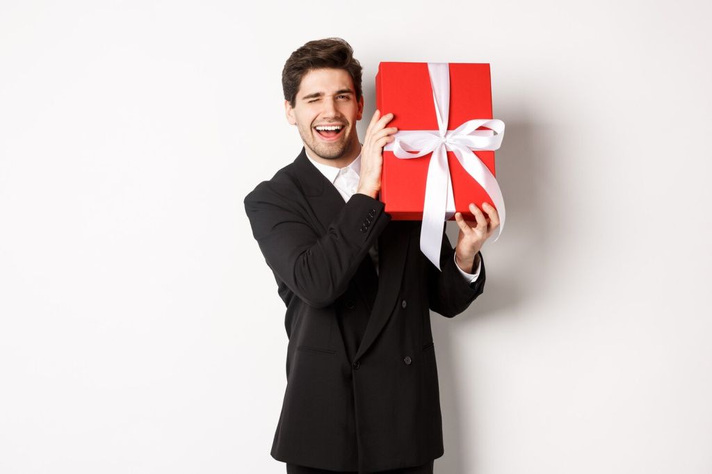 concept-christmas-holidays-celebration-lifestyle-attractive-man-black-suit-holding-new-year-gift-smiling-standing-with-present-white-background_1258-64799.jpg