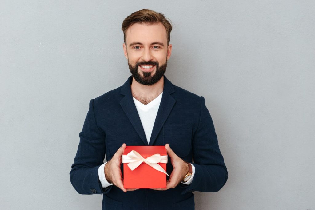 smiling-bearded-man-business-clothes-holding-gift_171337-11372.jpg