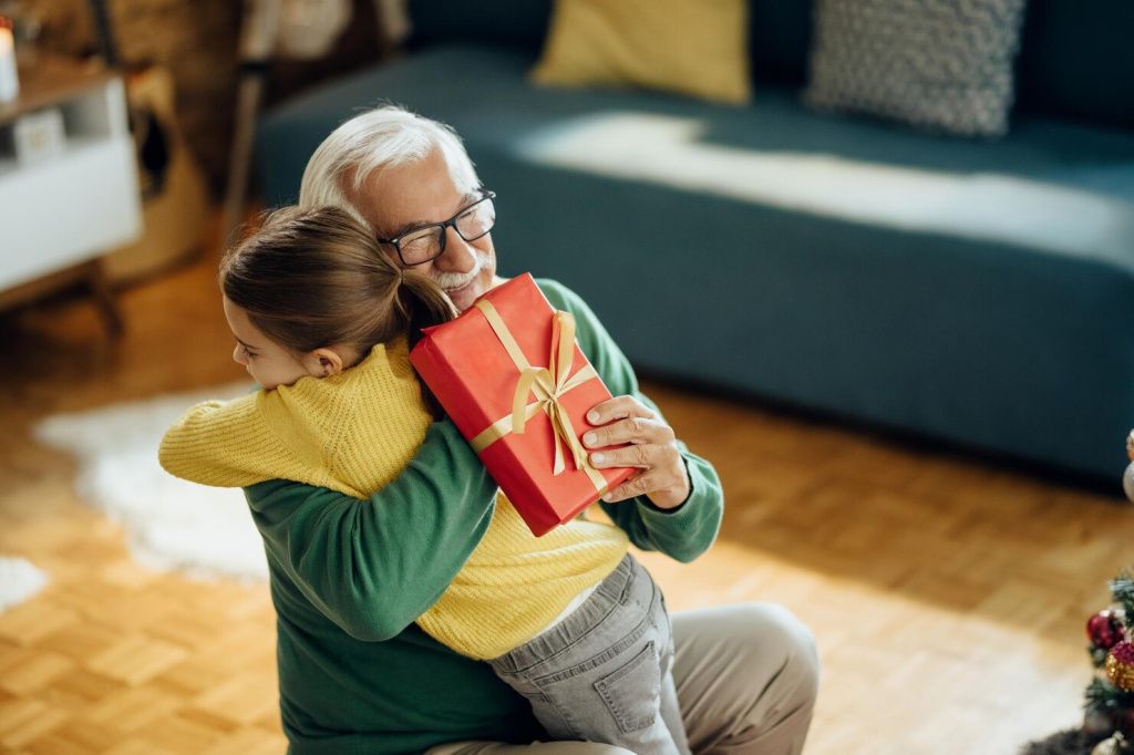 grateful-little-girl-embracing-her-grandfather-while-receiving-christmas-present-home_637285-10191.jpg